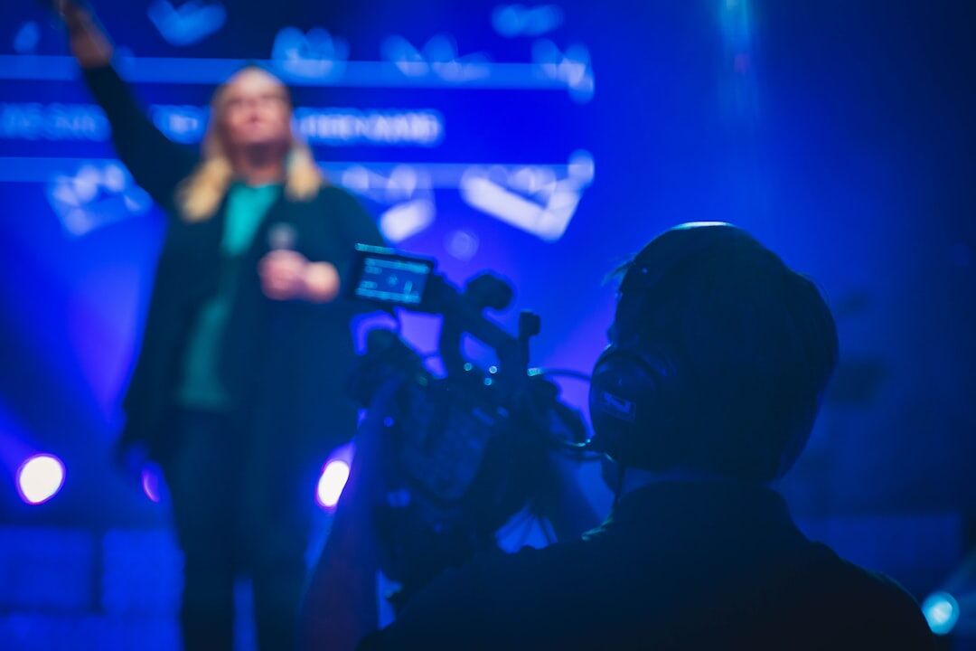 Journalist filming a live event with a crowd in the background